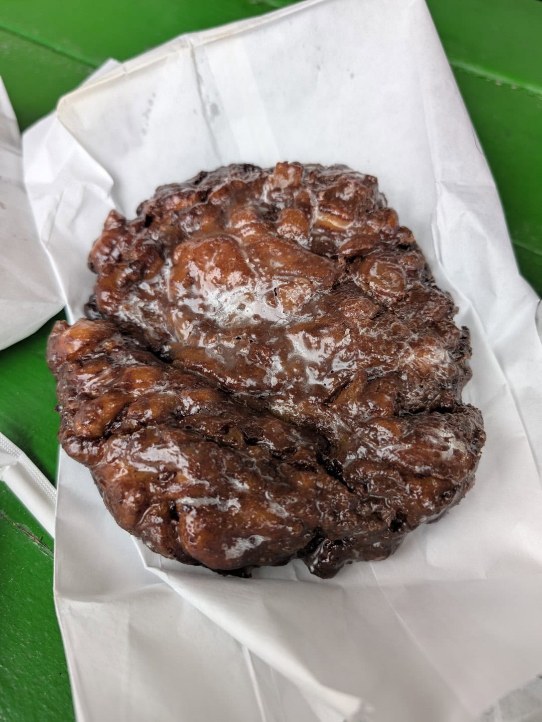 Giant glazed apple fritter on white bakery paper at Outlaw Donuts in Prescott, Arizona